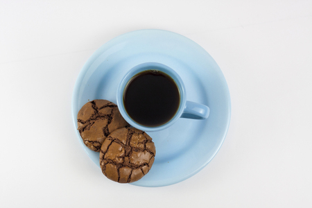 Black Brownie Cookies and blue coffee mug on a white background - top viewの写真素材