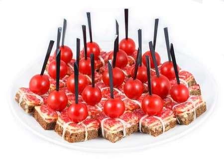 many multi-colored canapes arranged on a plate canapes in a white torch on a white foyer