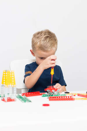 needlework, hand work a little boy collects a children's designer from metal