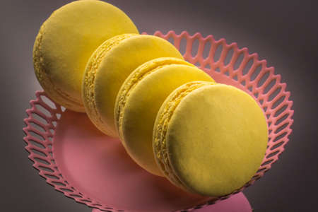 Yellow Macarons on a black background French pasta. Stack of yellow macaron with isolated on dark, black background. Macaroons.の写真素材