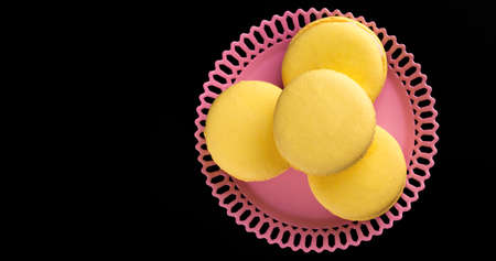 Yellow Macarons on a black background French pasta. Stack of yellow macaron with isolated on dark, black background. Macaroons.の写真素材