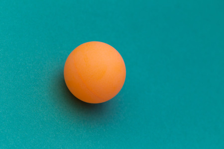 orange table tennis ball on a blue background