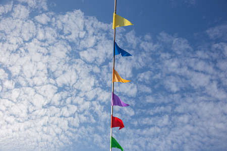 Colored triangular flags against the skyの写真素材