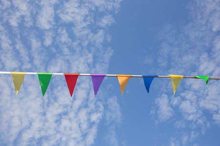 Colored triangular flags against the skyの写真素材