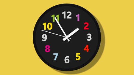 black wall clock with colorful numbers on yellow backgroundの写真素材