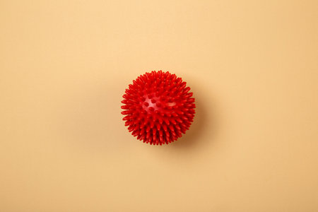Rubber massager. Red bumpy rubber sphere on yellow background.の写真素材