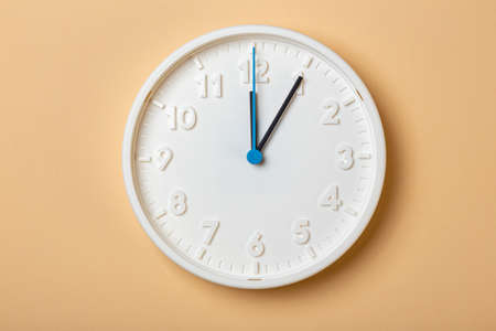 white wall clock with blue second hand show one oclock