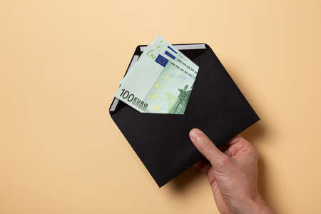 hand holds out an envelope euro banknotes