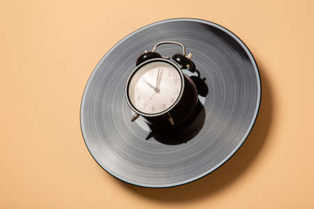 alarm clock lies on a vinyl record, time to listen to musicの写真素材