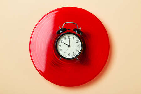 alarm clock lies on a vinyl record, time to listen to music