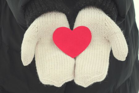 A red heart made of paper lies in the palm of hand.の写真素材