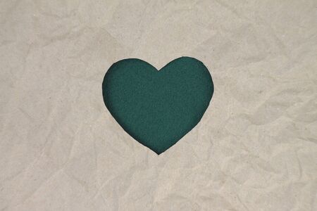 Green heart shaped slot in craft paper.の写真素材