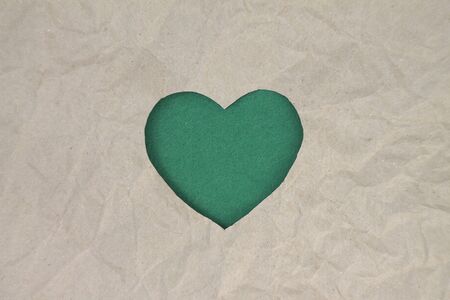 Green heart shaped slot in craft paper.の写真素材