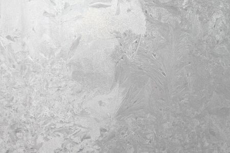 Blue window glass covered hoarfrost ice pattern texture. Cold nature winter background.の写真素材