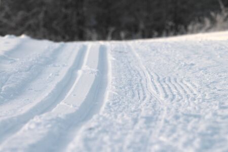 Ski track in snow. Hilly snowy surface. Active winter holiday concept. Stock photo for web and print, background, wallpaperの写真素材