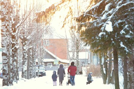 People walking down street on a sunny winter day. Trees covered with snow. Stock photo for web and print with empty space for text.の写真素材