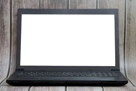 A laptop with a white screen stands on the background of wooden boards. Place for text, layout for...