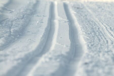 Ski track in snow. Hilly snowy surface. Active winter holiday concept. Stock photo for web and print, background, wallpaperの写真素材
