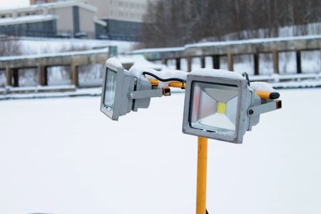 Led spotlight on yellow stand on winter urban background. Stock photo for web and print with empty space for text.の写真素材