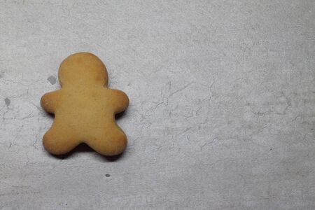 Gingerbread man on a gray textural background with space for text.の写真素材