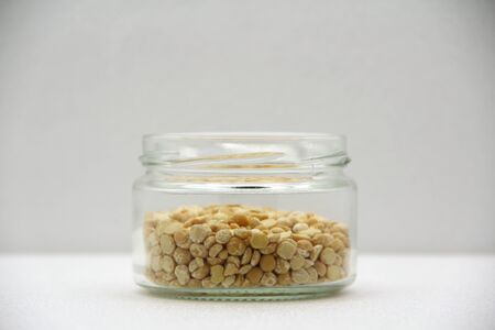 Glass jar with peas on a white background, side view. The concept of healthy nutrition, diets,...