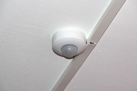 White motion sensor on the ceiling. Security, Automation and Alarm Concept.の写真素材