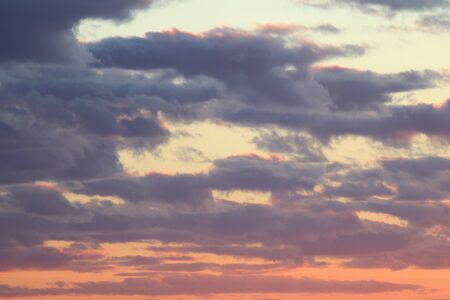 Clouds in the blue sky at sunset or dawn backlit by the sun. Place for text and design.の写真素材