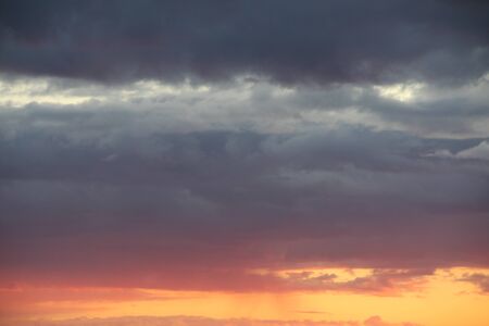 Clouds in the blue sky at sunset or dawn backlit by the sun. Place for text and design.の写真素材