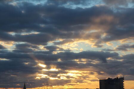 The suns rays pass through the dark clouds. Beautiful dramatic sky at sunset or sunrise.の写真素材