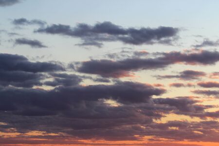 Clouds in the blue sky at sunset or dawn backlit by the sun. Place for text and design.の写真素材