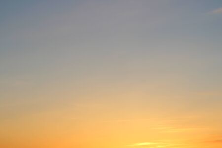 Sun below the horizon and fiery dramatic orange sky at sunset or dawn backlit by the sun. Place for text and design.の写真素材