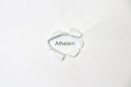 Word atheism on white isolated background, the inscription through the wound hole in the paper. Stock photo for web and print with empty space for text and design.の素材 [FY310144795499]