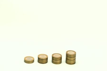 Piles of golden metallic coins. Columns of coins of different heights. The concept of business, economy, finance, investment and prices. Place for text and background for design.の写真素材