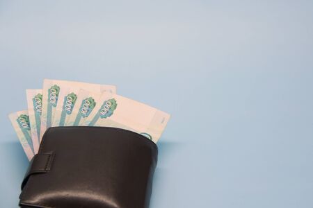 Leather brown wallet with Russian money sticking out of it in banknotes