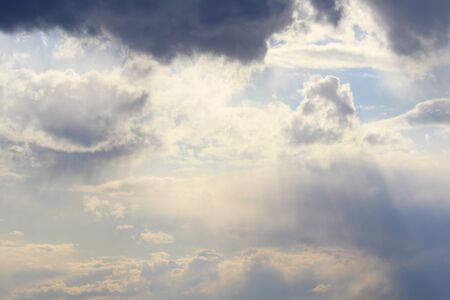 Clouds in the blue sky at sunset or dawn backlit by the sun. Place for text and design.の写真素材