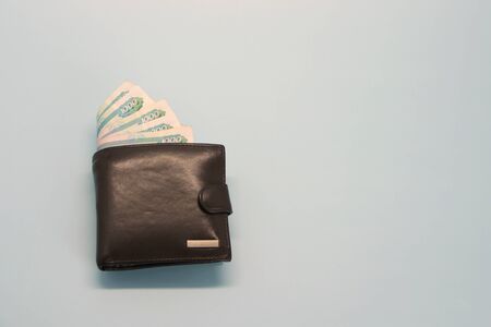 Leather brown wallet with Russian money sticking out of it in banknotesの写真素材