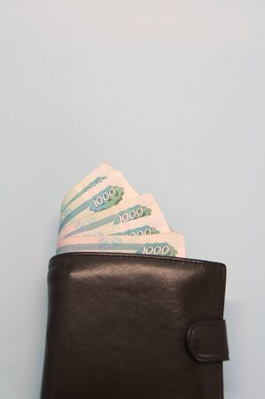Leather brown wallet with Russian money sticking out of it in banknotesの写真素材