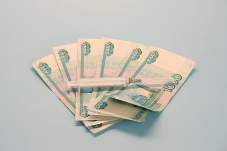 Russian money paper bills of one thousand rubles denominated in a fan. Thermometer lie on top.