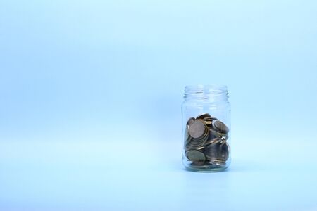 Metal coins, Russian rubles, lie in a transparent glass jar on a light background. Place for text and design.の写真素材