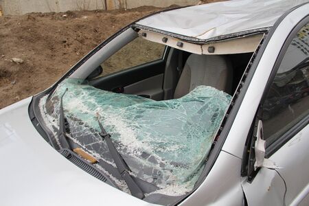 Broken windshield. A broken silver car after an accident on the road. Transport security concept.の写真素材