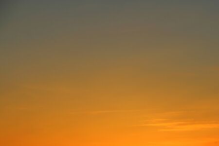 Sun below the horizon and fiery dramatic orange sky at sunset or dawn backlit by the sun. Place for text and design.の写真素材