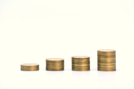 Piles of golden metallic coins. Columns of coins of different heights. The concept of business, economy, finance, investment and prices. Place for text and background for design.の写真素材