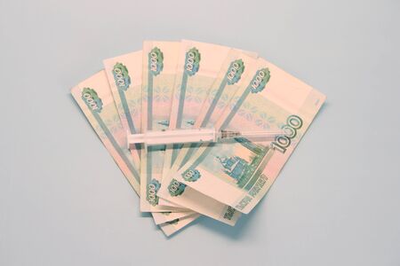 Russian money paper bills of one thousand rubles denominated in a fan. Thermometer lie on top.の写真素材