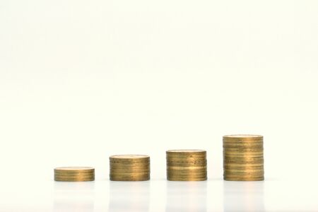 Piles of golden metallic coins. Columns of coins of different heights. The concept of business, economy, finance, investment and prices. Place for text and background for design.の写真素材