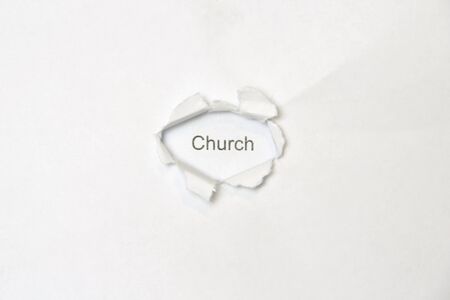 Word church on white isolated background, the inscription through the wound hole in the paper. Stock photo for web and print with empty space for text and design.の写真素材