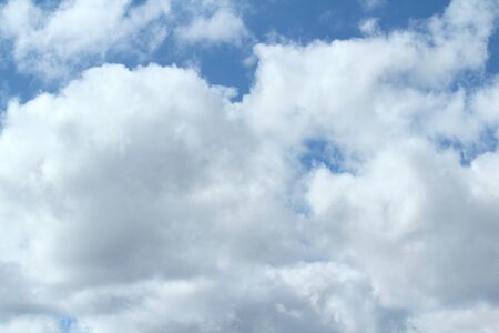 Clouds in the blue sky at sunset or dawn backlit by the sun. Place for text and design.の写真素材
