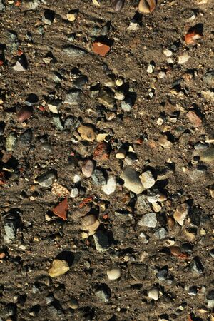 Small stones and sand. The natural texture of the soil. Shore of a reservoir with a beach and pebbles.の写真素材