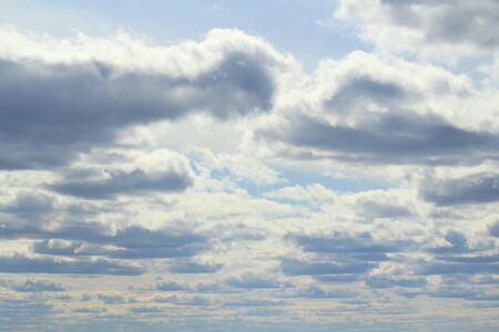 Clouds in the blue sky at sunset or dawn backlit by the sun. Place for text and design.の写真素材