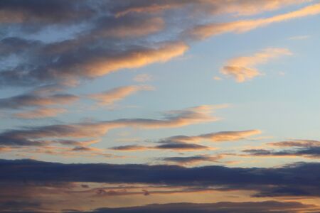 Clouds in the sky are illuminated from below by the red light of the sun. Sunset or sunrise scene at dusk.の写真素材