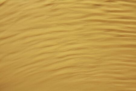 Yellow wavy striped background. Waves and ripples on the water. Place for text and design.の写真素材